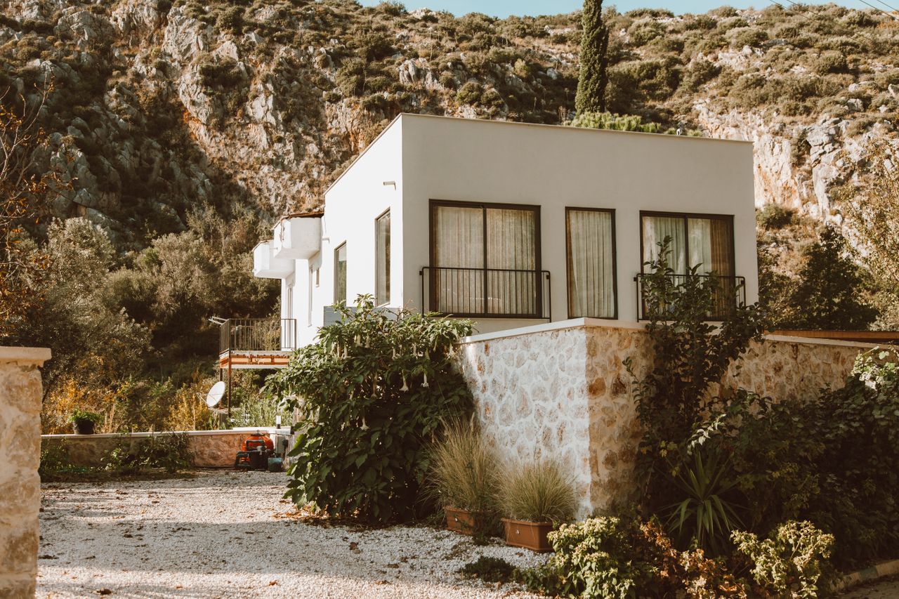 Contemporary house nestled in a sunlit rocky outdoor setting, perfect for architecture lovers.